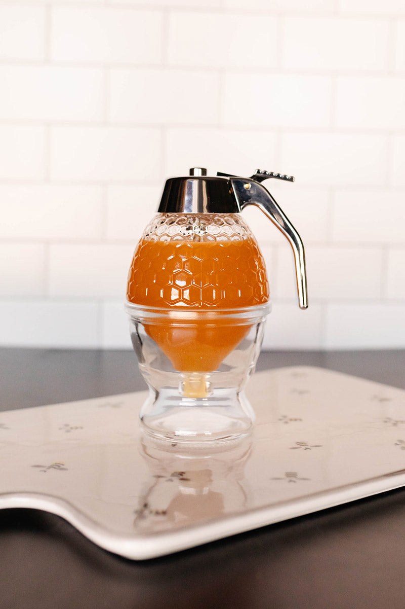 Glass honey dispenser with trigger release